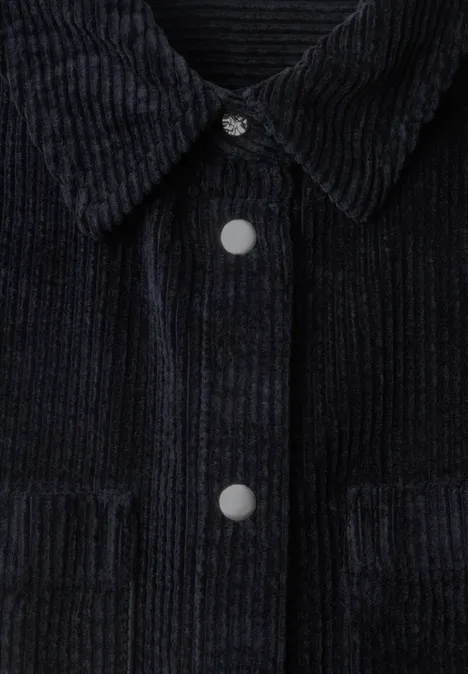 Schwarze Cordjacke mit Kragen, Metall-Druckknöpfen und Brusttaschen, feine Rippenstruktur.