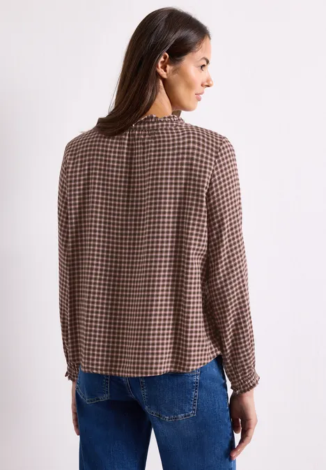 Blouse met lange mouwen, ronde hals en ruches warm blush Eine Frau steht mit dem Rücken zur Kamera und trägt eine braun-karierte Bluse.