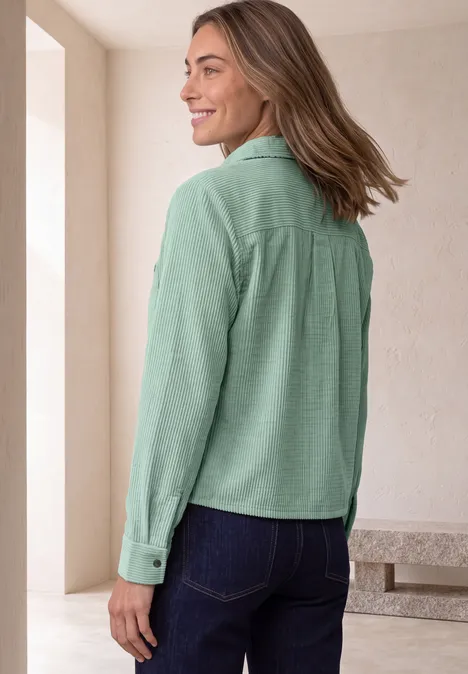 Overhemdblouse van corduroy met borstzakken eucalyptus green Frau in grünem Hemd steht seitlich und lächelt.