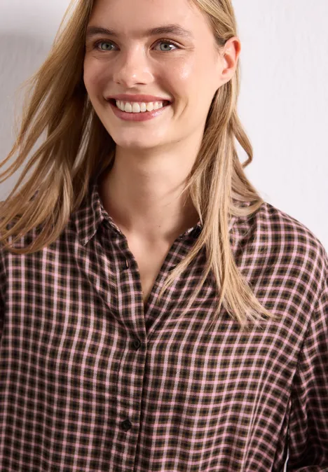 Bluzka z rękawami 3/4 w kratkę warm blush Uśmiechnięta blondynka ma na sobie brązową kratowaną koszulę na tle białej ściany.