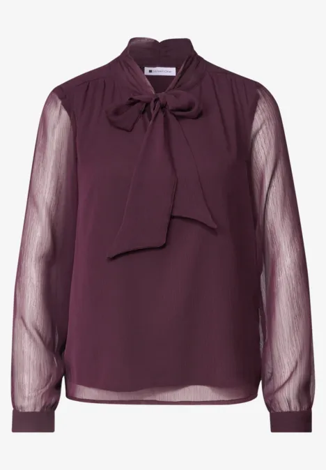 Dunkellila Chiffonbluse mit Schleifenkragen und transparenten Ärmeln.