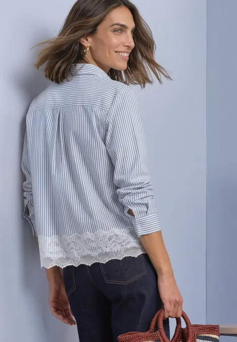 Chemisier à manches longues, rayé et orné d'une bordure en dentelle northern blue Frau in blau-weiß gestreiftem Hemd mit Spitzenabschluss und Jeans blickt über die Schulter.