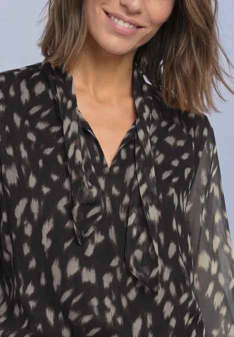 Chemisier à manches longues en chiffon avec nœud décoratif Black Eine lächelnde Frau in schwarzer, transparent gemusterter Bluse mit Rüschenkragen.