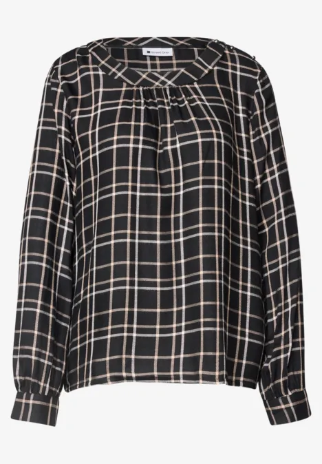 Schwarze Bluse mit beigen Karos, langärmlig mit Falten am Ausschnitt und Manschetten.