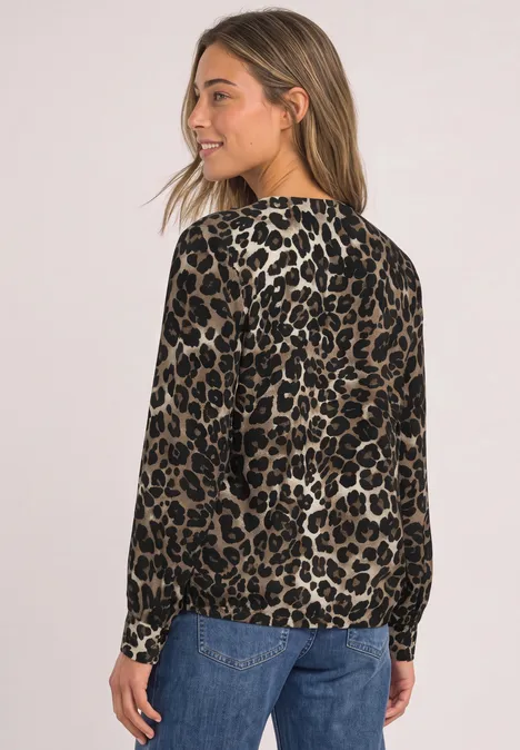 Langarm Bluse mit Rundhals und Cut-Out Black Junge Frau in seitlicher Pose trägt langärmlige Bluse im Leopardenmuster und blaue Jeans vor neutralem Hintergrund.