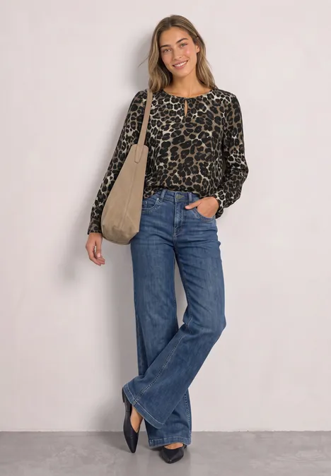 Langarm Bluse mit Rundhals und Cut-Out Black Junge Frau trägt Leo-Print-Pullover, weite Jeans und Tasche