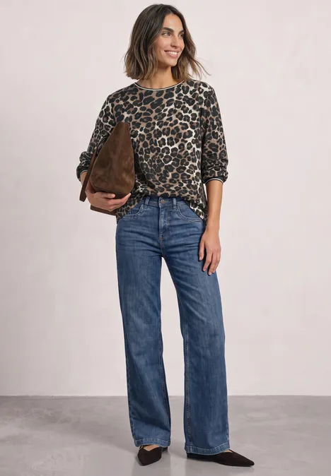 Chemisier à manches longues avec détails en bande et imprimé léopard Black Frau trägt lässiges Leopardenmuster-Oberteil, blaue Jeans mit weitem Bein und braune Handtasche.
