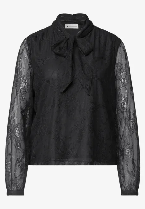 Eine schwarze Spitzenbluse mit langen Ärmeln und Schleifendetail am Kragen.