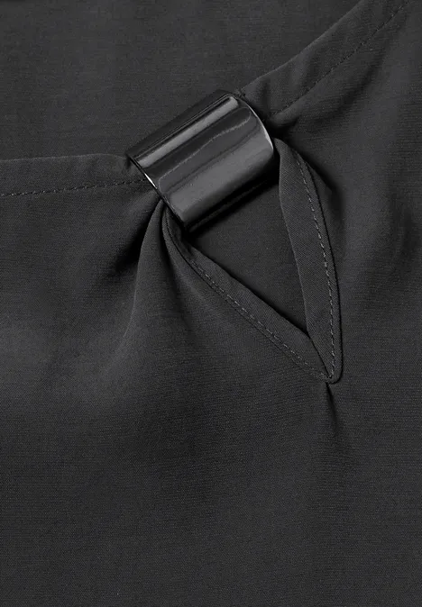 Blouse col rond à boucle décorative armor grey Gros plan d'un vêtement noir avec poche surpiquée et anneau métallique noir intégré.