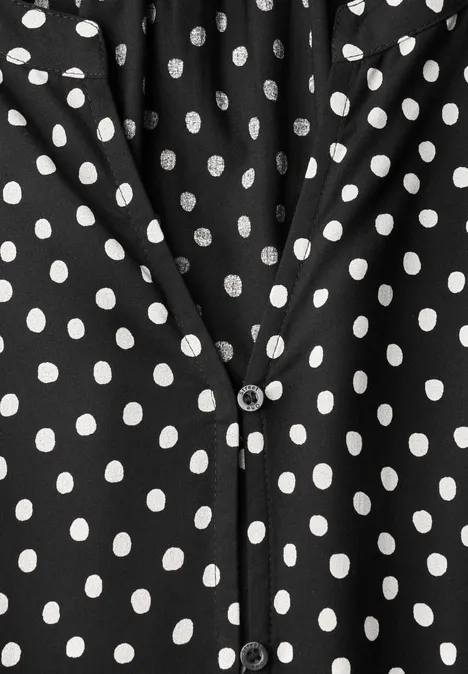 Chemisier à manches longues, à col fendu et imprimé Black Schwarzes Kleidungsstück mit weißen Polka-Dots und V-Ausschnitt, vorn mit Knopfverschluss.