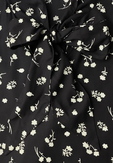 Schwarzer Stoff mit zarten weißen Blüten und Knoten-Detail
