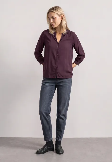 3/4-Arm Bluse mit Split Neck und Glitzer berry plum Eine Frau trägt eine lila Hemdjacke, Jeans und schwarze Stiefeletten, steht vor neutralem Hintergrund.