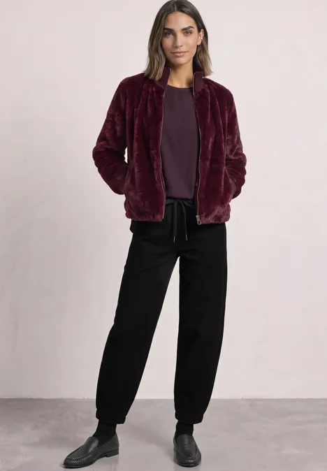 Blouse courtes manches à col rond et bandes pailletés berry plum Femme portant une veste teddy bordeaux, tee-shirt assorti et pantalon noir ample