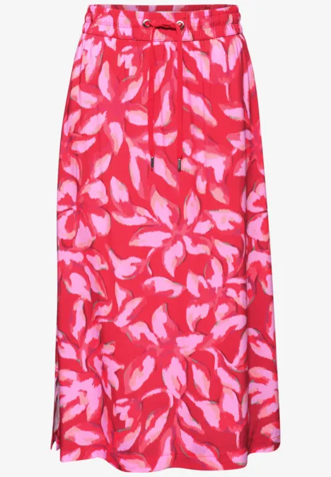 Lange rode rok met roze bladerenpatroon, elastische taille en ceintuur.