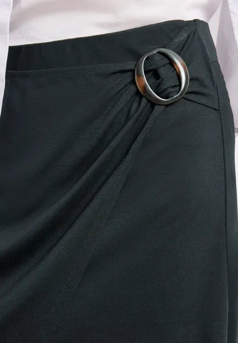 Schwarzer Wickelrock mit großer silberner Ringschnalle an der Seite.