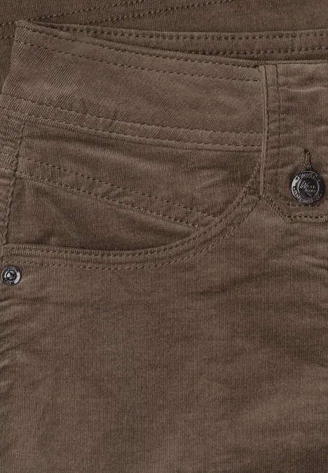 Close-up van een bruine ribfluwelen broek met zakken en knopen.