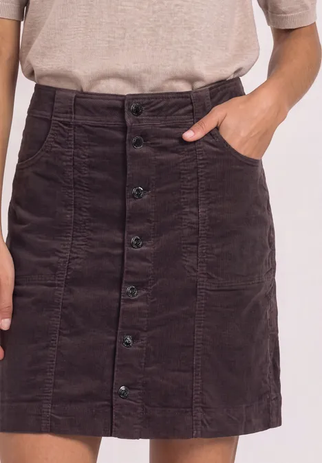 Bruine corduroy rok met knoopsluiting voor en steekzakken, gecombineerd met een beige top