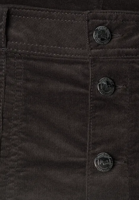 Close-up van donkerbruine corduroy stof met drie metalen knoppen.