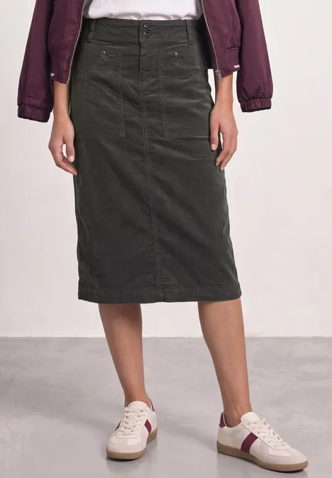 Dunkelgrüner Cord-Midirock mit geradem Schnitt, hoher Taille und seitlichen Taschen, kombiniert mit Sneakern.