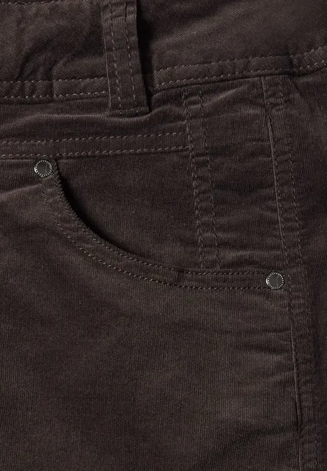 Gros plan d’un pantalon en velours côtelé marron foncé avec poche avant.