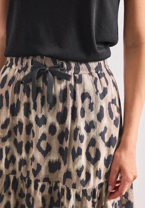 Beige-leopardenmusterer Rock mit gerafftem Saum und Schleifbund, kombiniert mit schwarzem Top.
