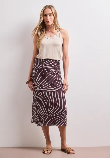 Midirok van mesh met print rustic rouge Vrouw met wit topje en midi-rok met zebraprint.