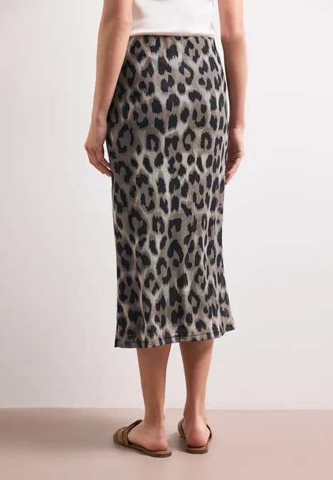 Midirok van mesh met print timeless beige Rugaanzicht van iemand met witte top, een midi rok met panterprint en platte sandalen.