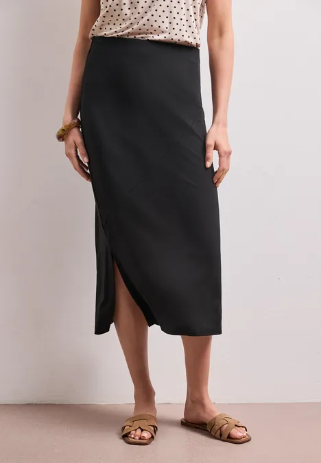 Midirok van tricot in effen kleur Black Zwarte midirok met zijsplit, gecombineerd met platte sandalen.