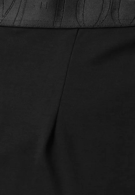 Midirok van tricot in effen kleur Black Close-up van een zwart kledingstuk met reliëfband en verticale naad.