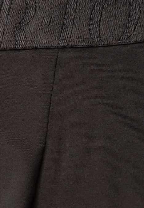 Gros plan sur un tissu noir avec couture et ceinture élastique.