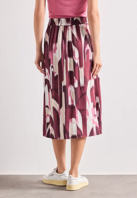 Midi-Rock mit Knopfleiste und Print rustic rouge Modischer Midirock mit abstraktem rosa-lila Muster, weich fallend und kombiniert mit weißen Sneakern.