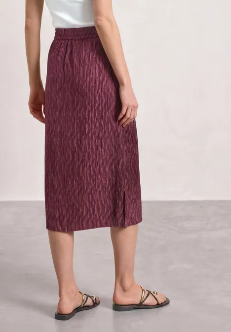 Midirock mit Elastikbund und Print blush berry Seitlicher Blick auf Frau mit körpernahem, bordeauxrotem, gemustertem Midirock und schwarzen Riemchensandalen.
