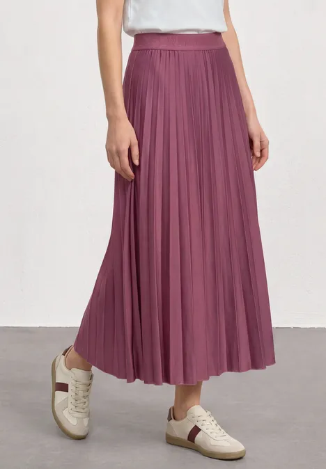Jupe midi à structure plissée dark clouded blush Une personne porte une jupe plissée longue couleur prune avec des baskets blanches.