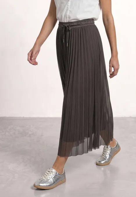 Midirock aus Mesh in Plisséestruktur black coffee Frau trägt grauen, plissierten Maxirock und silberne Sneaker, nur Beine und Unterkörper sichtbar.