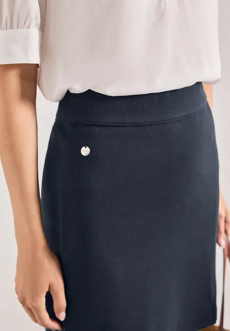 Damenoberteil mit weißer Bluse und dunkelblauem Rock mit kleinem Herzdetail.