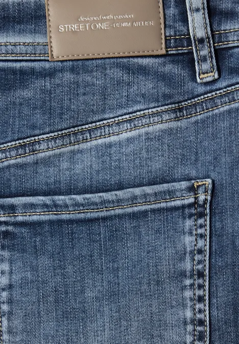 Nahaufnahme einer blauen Street One Jeanshose mit Gesäßtasche und braunem Markenlabel.
