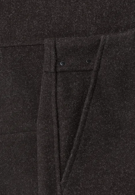 Knielanger Rock in Wolloptik black coffee mel. Nahaufnahme einer schwarzen Hose mit eingenähter Tasche und feinen Ziernähten.