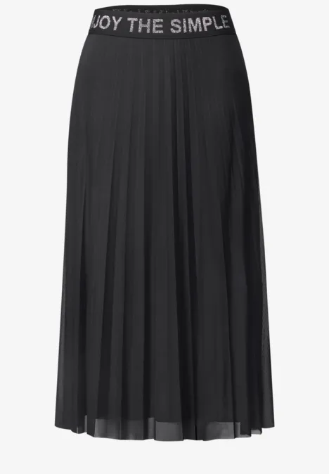 Zwarte, geplooide midirok met elastische tailleband en de tekst ‘ENJOY THE SIMPLE’.