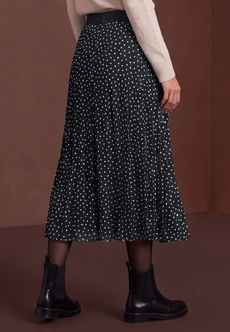 Schwarzer Midirock mit weißen Polka Dots, kombiniert mit schwarzen Stiefeln.