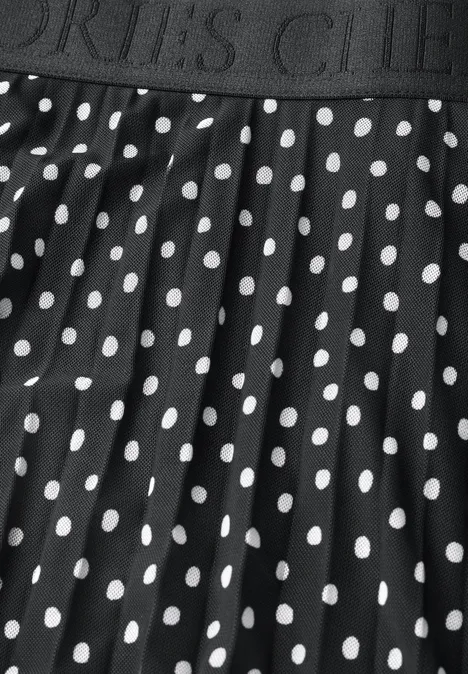 Ein schwarzer Rock mit weißem Polka-Dot-Muster und elastischem Bund mit Aufschrift 'SPORTS CLUB'.