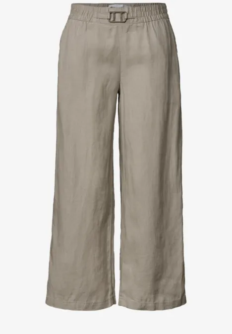 Beige linnen broek met wijd model, elastische taille en klein gespje vooraan.