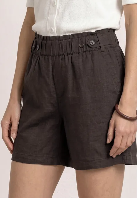 Donkerbruine linnen short met hoge, elastische taille en knoopdetail, gecombineerd met een eenvoudig wit topje.