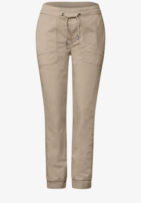 Licht beige vrijetijdsbroek met elastische taille, trekkoord en elastische boorden aan de pijpen.
