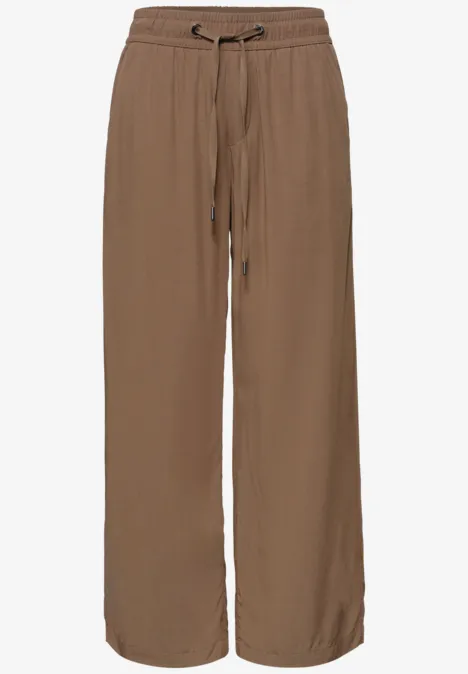 Loszittende, bruine broek van stof met wijde pijpen en een koordsluiting in de taille.