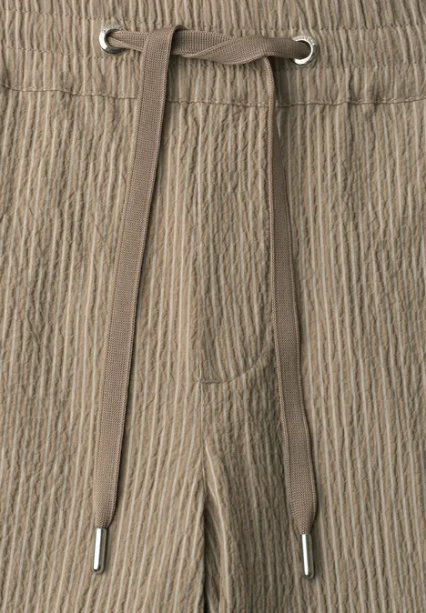 Taupekleurige broek met kreukstructuur en tunnelkoord.