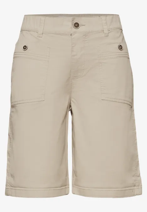Beige cargoshort met opgestikte zakken, riemlussen en knoopsluiting van licht materiaal.