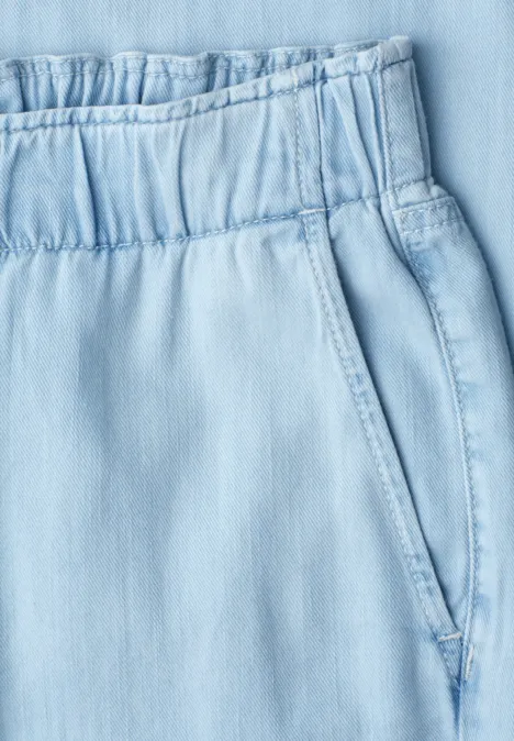 Hellblaue Hose mit elastischem Bund und sichtbarer Seitentasche.