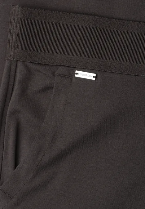 Schwarze Hose mit seitlicher Tasche und kleinem silbernem Label oberhalb der Tasche.