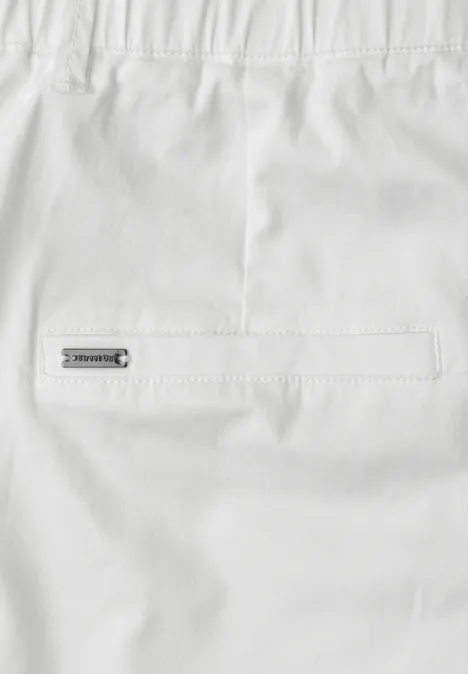 Weißes Kleidungsstück mit Gesäßtasche und kleinem Metall-Label auf der Rückseite.