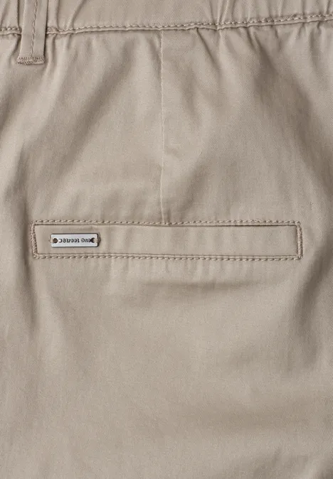 Mid Waist chino shorts in een casual pasvorm buff grey Close-up van een lichtbeige broek met een gesloten achterzak en een klein merkembleem.
